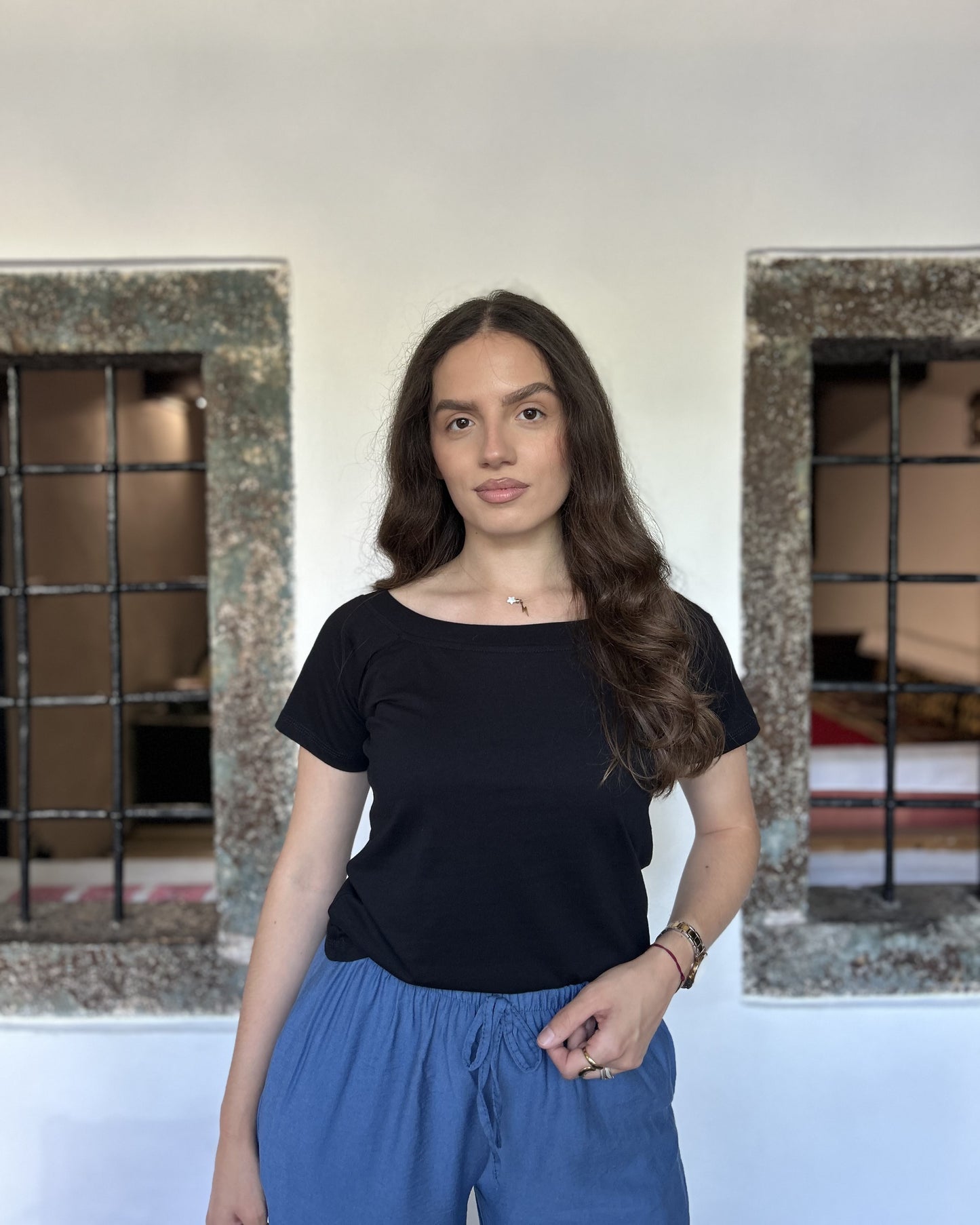 Sindy crna majica — detalj struka i vezanja plavih pantalona, portretni kadar