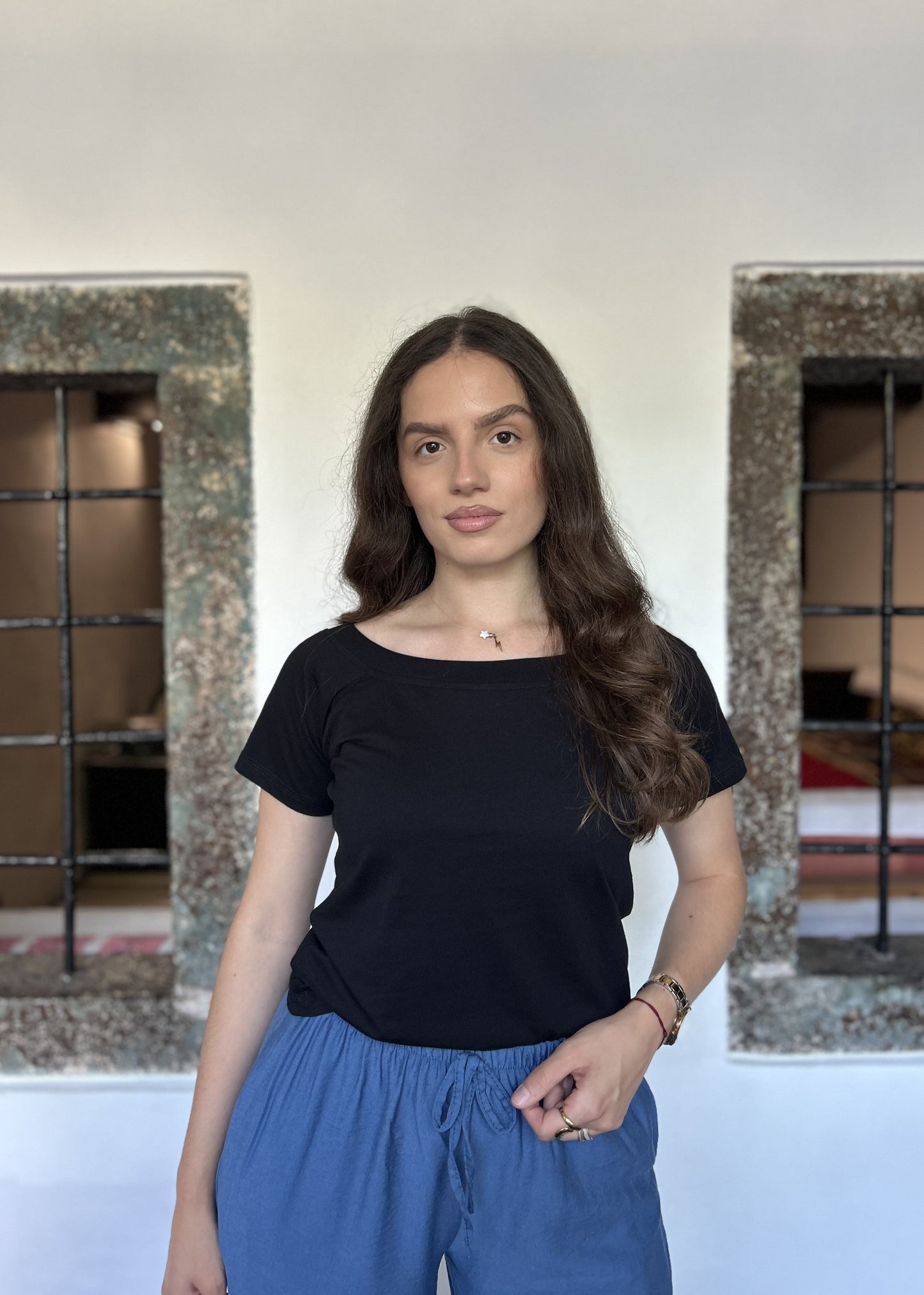 Sindy crna majica — detalj struka i vezanja plavih pantalona, portretni kadar