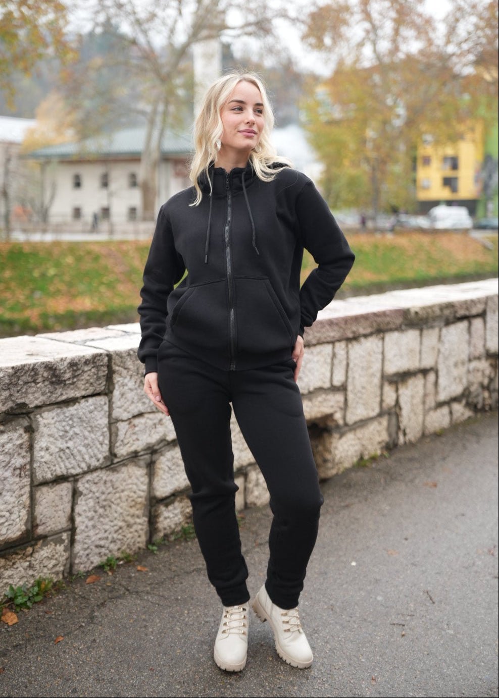 Žena nosi Trenerku sa rajfešlusom u vanjskom okruženju.