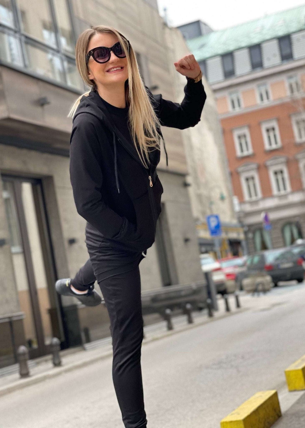 Žena u crnoj dukserici Nella s kapuljačom i rajfešlusom na otvorenom