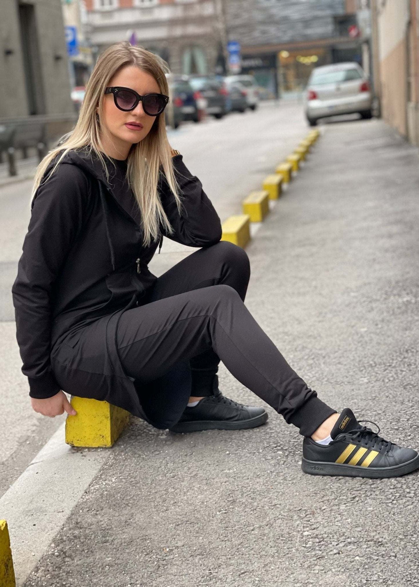Žena u crnoj dukserici Nella s kapuljačom i rajfešlusom na otvorenom