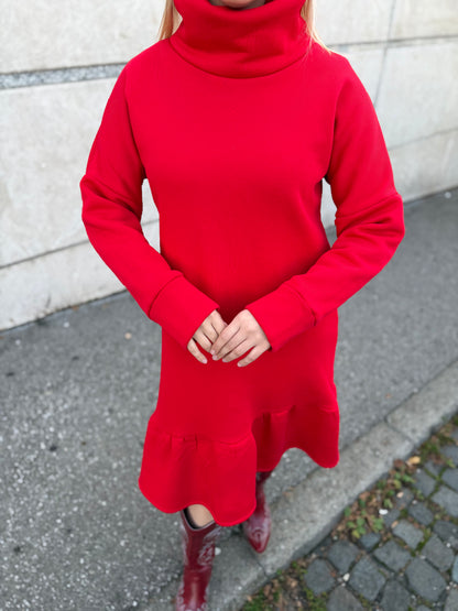 Žena u crvenoj rolka haljini Demy s volanom u ulici.
