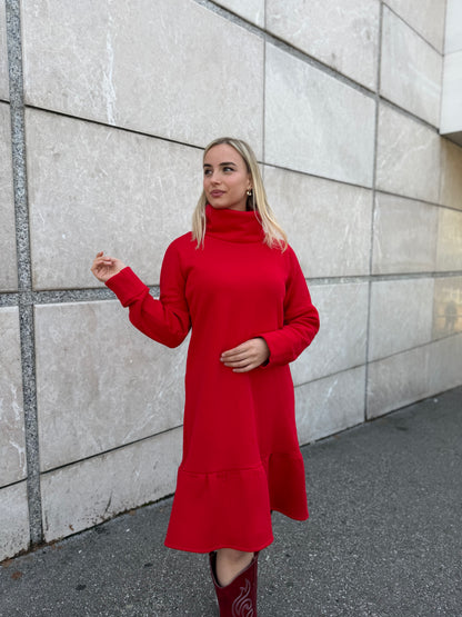 Žena u crvenoj rolka haljini Demy s volanom u ulici.