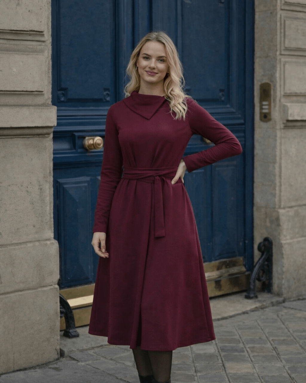Žena nosi Anita midi bordo  haljinu A kroja s pojasom u struku.