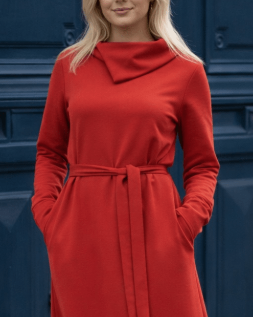 Žena nosi Anita midi crvenu  haljinu A kroja s pojasom u struku.