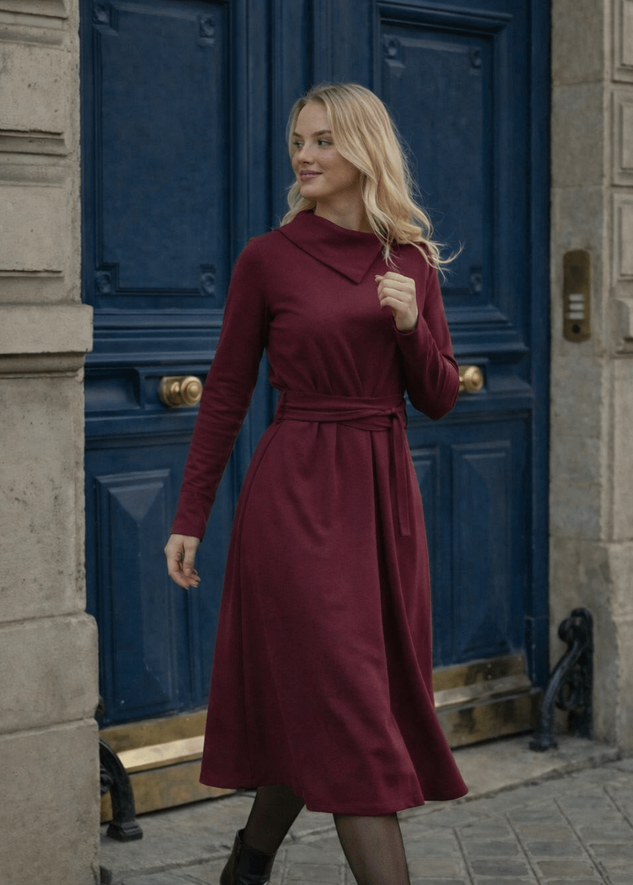 Žena nosi Anita midi bordo  haljinu A kroja s pojasom u struku.