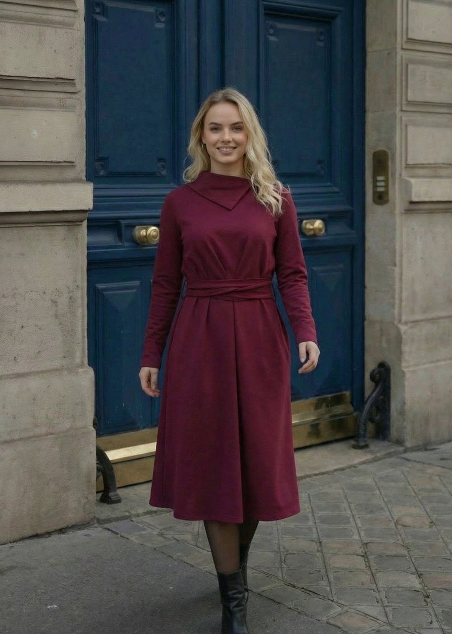 Žena nosi Anita midi bordo  haljinu A kroja s pojasom u struku.