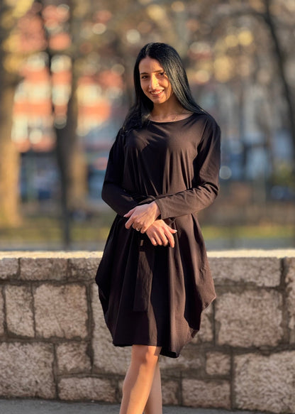  Žena u crnoj asimetricnoj B- Fiume haljini s dugim rukavima  u vanjskom prostoru.