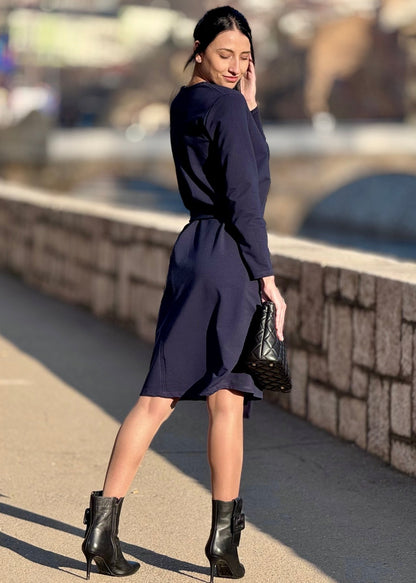  Žena u teget asimetricnoj B- Fiume haljini s dugim rukavima  u vanjskom prostoru.