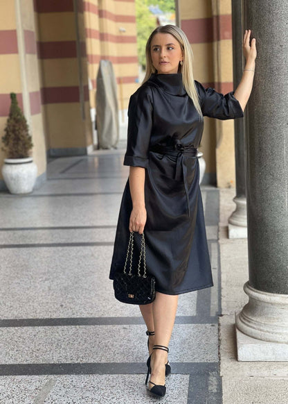 Elegantna satenska crna midi haljina Revija s okovratnikom i pojasom u struku.