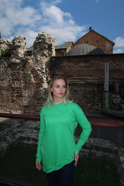Žena u asimetričnoj kosoj pamučnoj majici u zelenoj  boji.