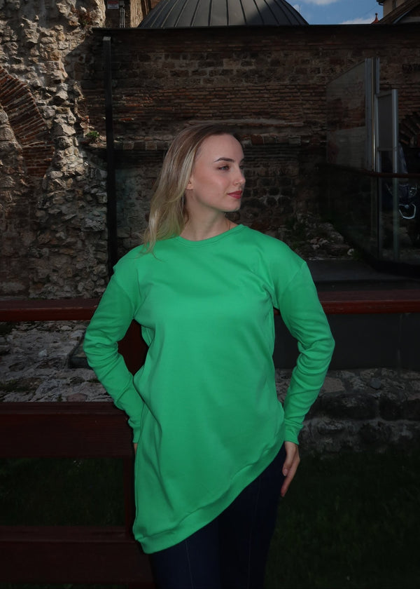 Žena u asimetričnoj kosoj pamučnoj majici u zelenoj  boji.
