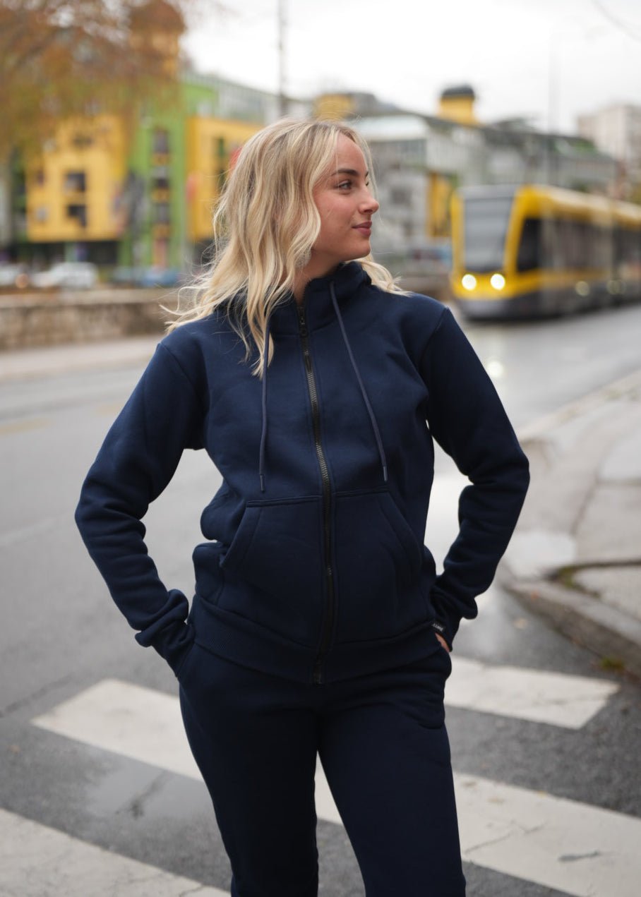 Žena nosi Trenerku sa rajfešlusom u vanjskom okruženju.