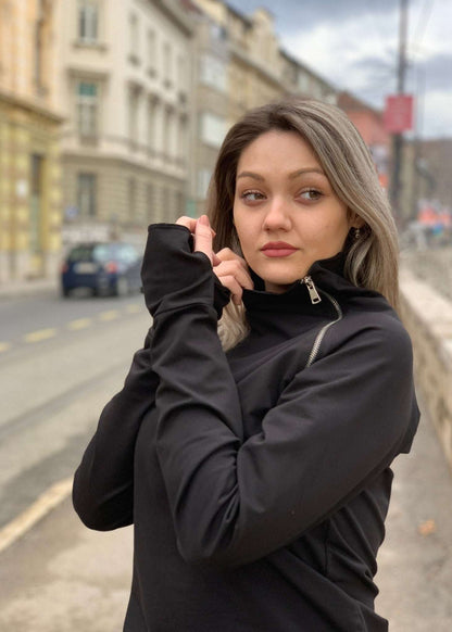 Žena u crnoj majici s asimetričnim rajfešlusom, visokim ovratnikom i dugim rukavima