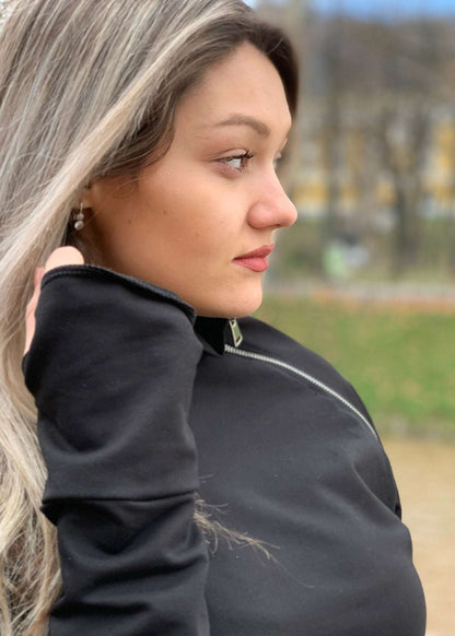 Žena u crnoj majici s asimetričnim rajfešlusom, visokim ovratnikom i dugim rukavima